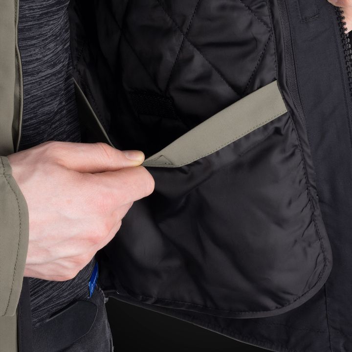 A close-up of a person's hands zipping up a black jacket.