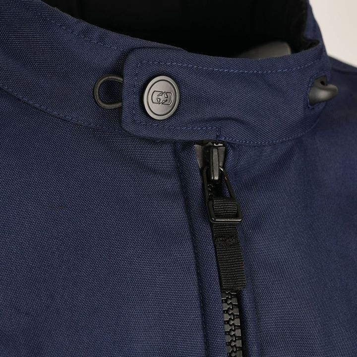 Close-up of a blue jacket collar with a zipper and a branded button fastener.