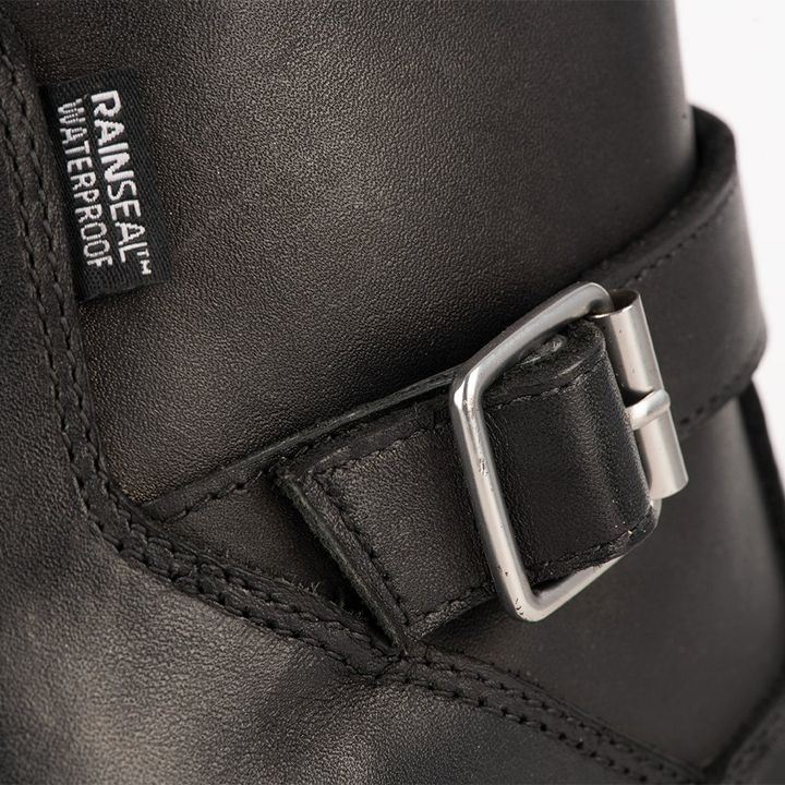 Close-up of a black waterproof boot with a silver buckle and "RAINSEAL™ WATERPROOF" label.