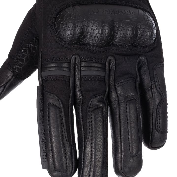 A close-up of a black motorcycle glove with reinforced padding and the brand name "OXFORD" visible.