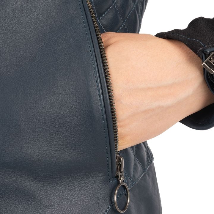 A close-up of a person's arm with a partially unzipped leather jacket sleeve, displaying the zipper and the texture of the leather material.