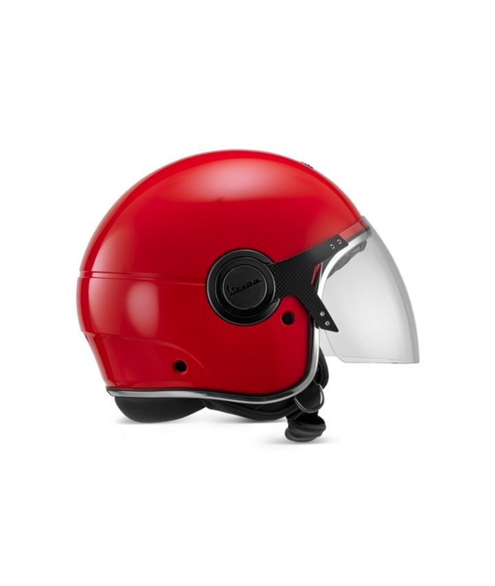 A red Vespa motorcycle helmet with a clear visor, isolated on a white background.