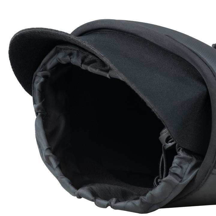 A close-up view of a black fabric hat with a wide brim, featuring an adjustable strap and an interior lining.