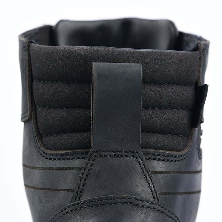 Close-up of the back of a black leather shoe with a padded collar and pull tab.