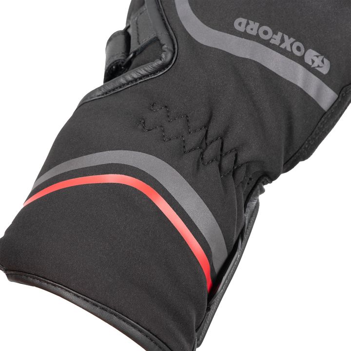 Close-up of a black cycling glove with reflective gray elements and a red accent, featuring a hook-and-loop wrist closure and reinforced palm area.