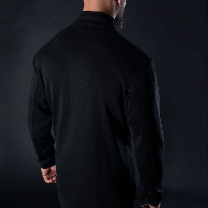 Rear view of a person wearing a black turtleneck sweater against a dark background.