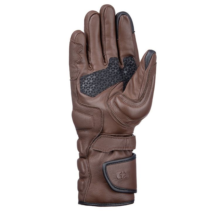 A single brown leather motorcycle glove with reinforced padding on the backhand, grip-enhancing texture on the palm, and an adjustable wrist strap.