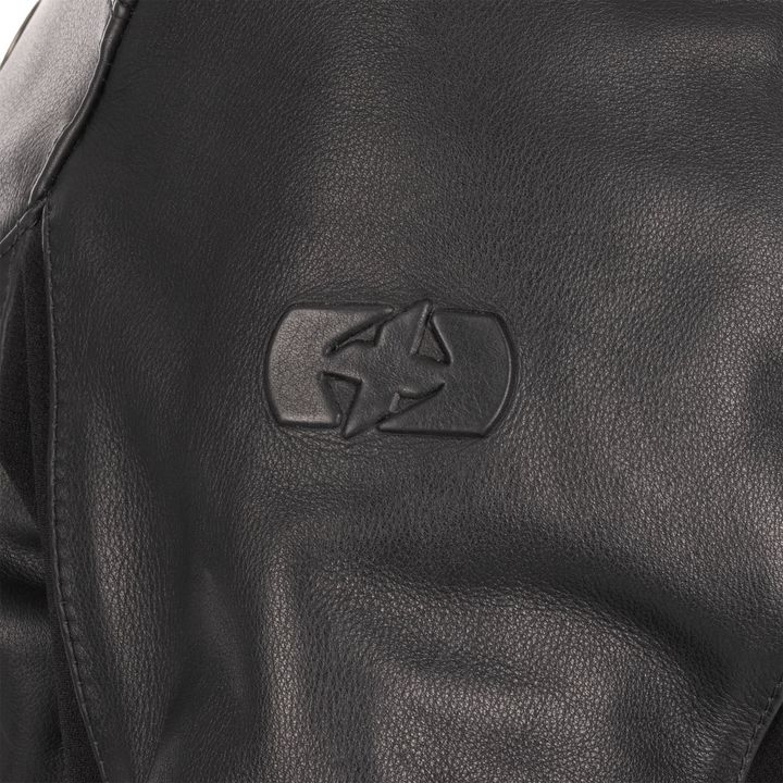 Close-up of a black leather texture with a debossed recycling symbol.