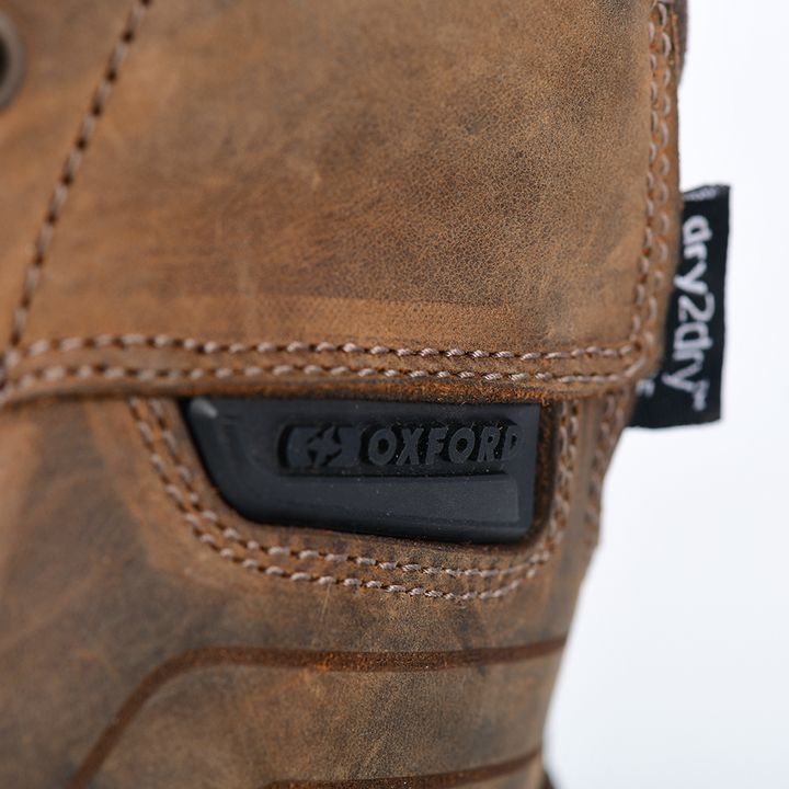 Close-up of a brown leather boot with visible stitching, featuring an 'OXFORD' brand name embossing.