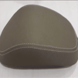 A triangular-shaped, chocolate brown headrest with visible stitching on the front, against a light background.