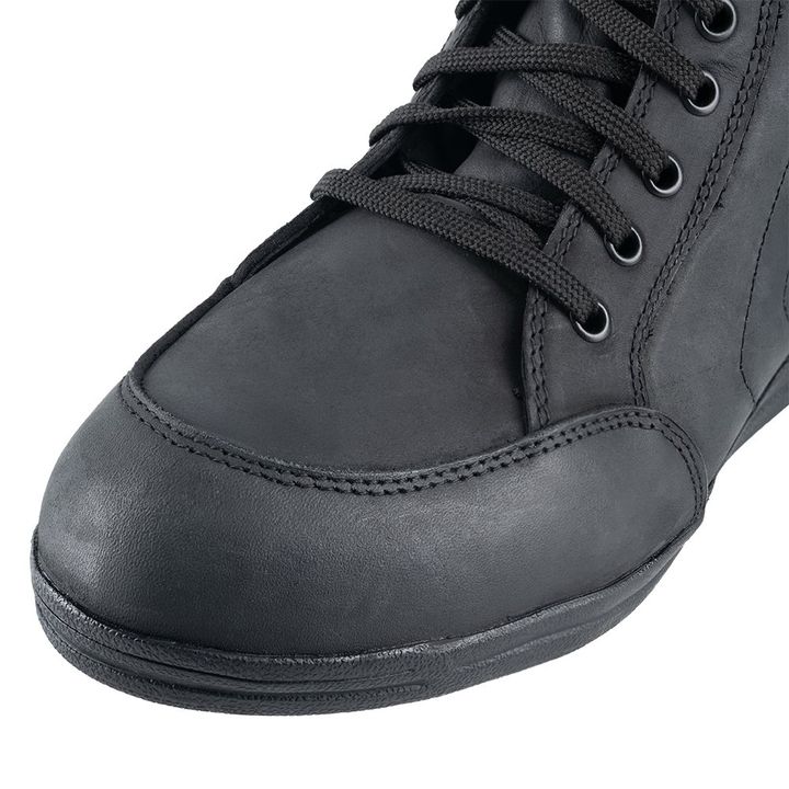 Close-up of a black leather shoe with laces on a white background.