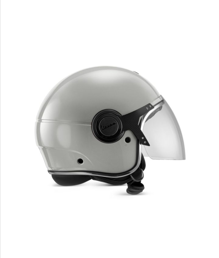 A silver Vespa motorcycle helmet with a clear visor and black accents, displayed against a white background.