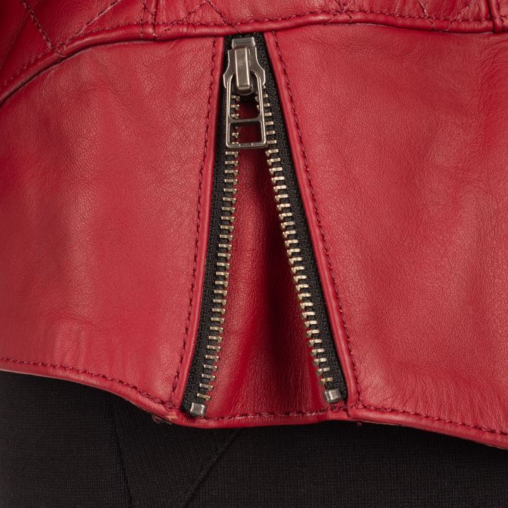 A close-up of a red leather jacket with a silver zipper partially unzipped.